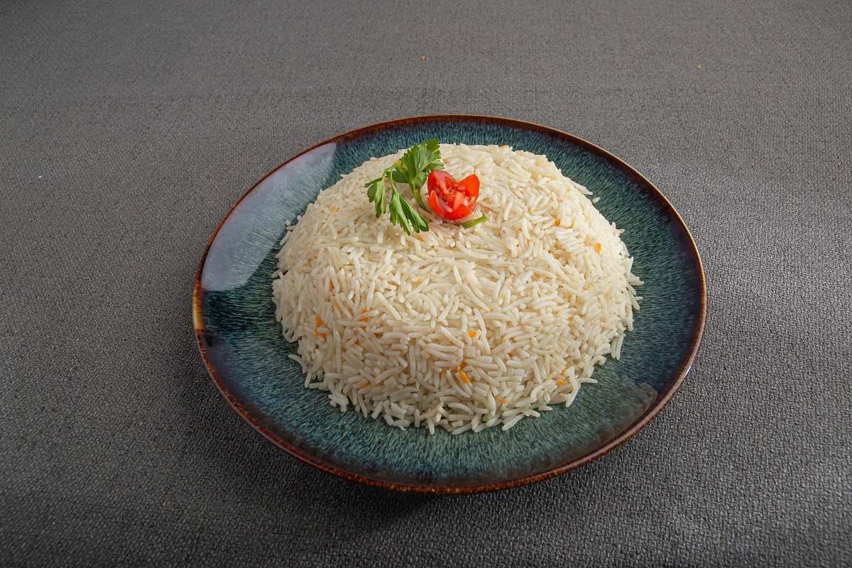 cooked basmati rice topped with parsley and a tomato slice