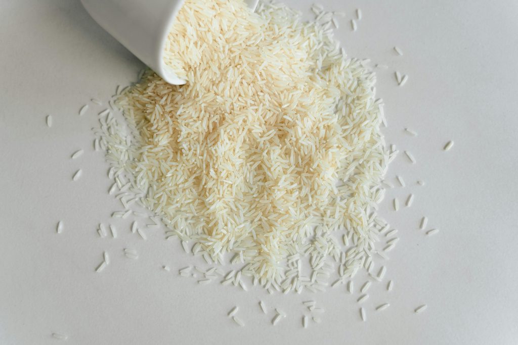 dry long grain rice spilling out of a cup