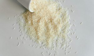 dry long grain rice spilling out of a cup