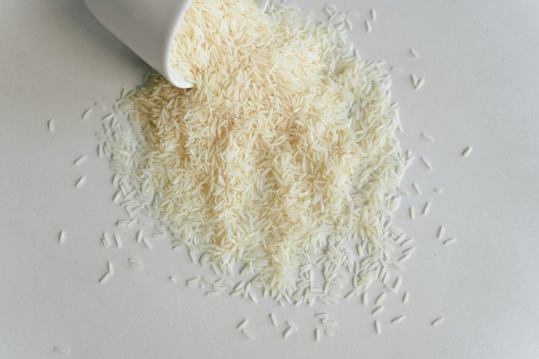 dry long grain rice spilling out of a cup