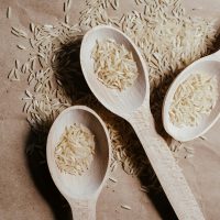three wooden spoons with grains of rice